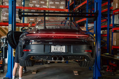 Porsche GT3RS on a lift in a warehouse setting with visible license plate