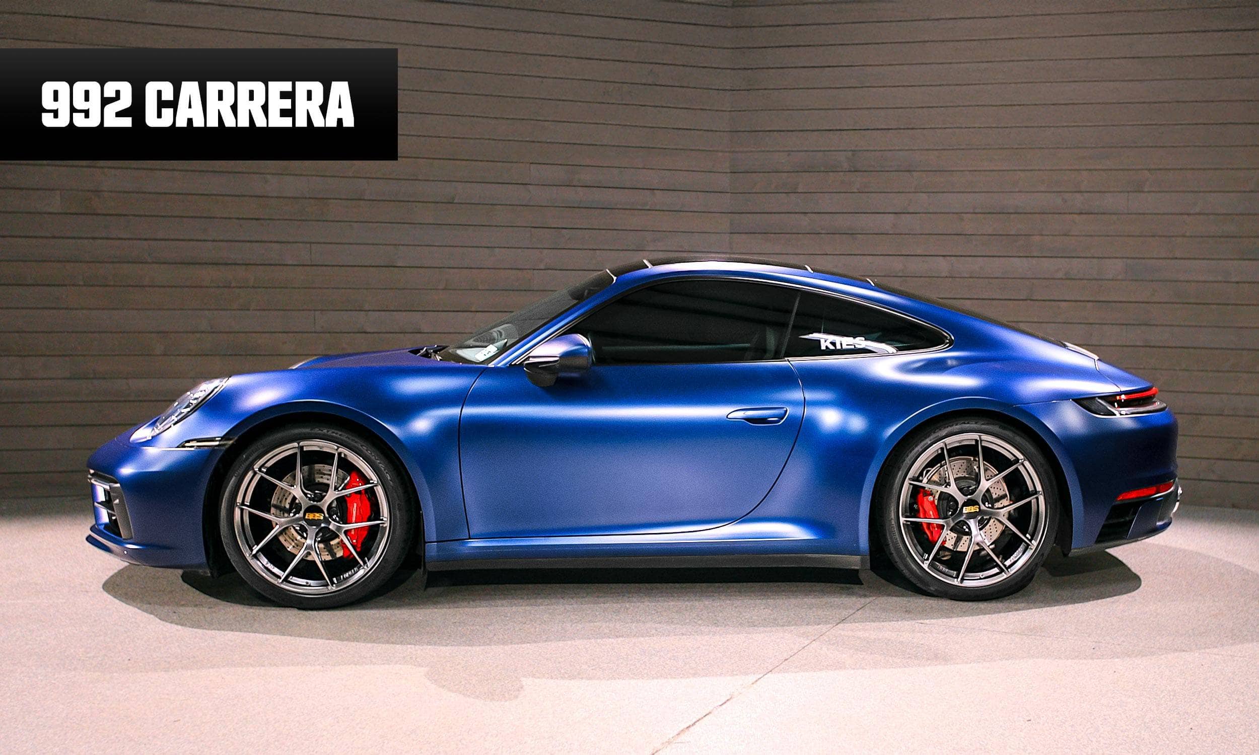 Blue Porsche 992 Carrera car on a gray background