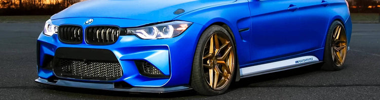 Blue BMW F30 car with gold rims on a road