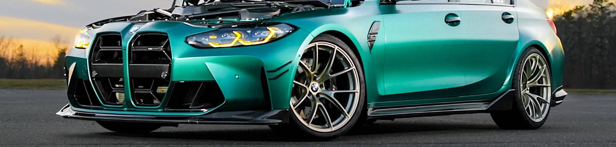 Green BMW g80 car on a road with a blurred background