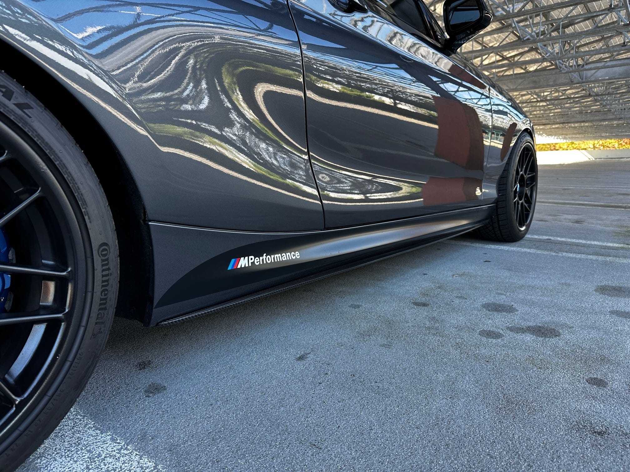Kies Motorsports — carbon fiber side skirt extension pre-installation for BMW F22/F23, showing underside mounting surface and hardware