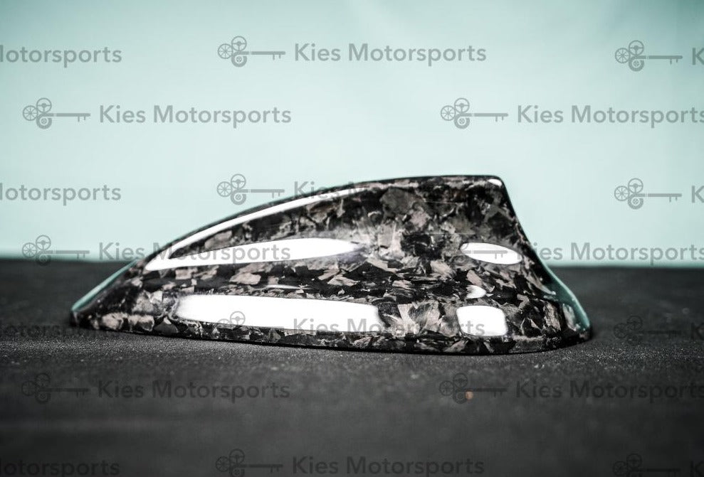 Kies Motorsports — forged carbon fiber shark fin antenna overlay installed on BMW F30/F32 roof, showing the distinctive forged carbon marbled pattern Main image