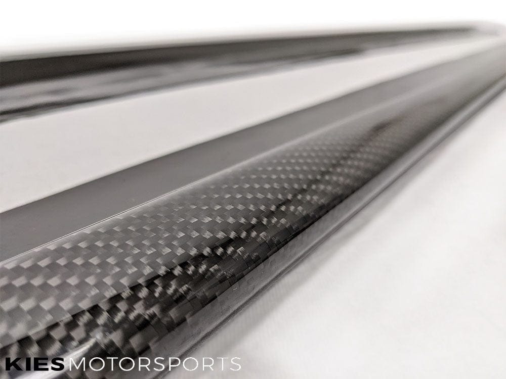 Kies Motorsports — pair of Kies Carbon 3D style side skirt extensions for F32/F33 laid out before installation, carbon fiber gloss finish